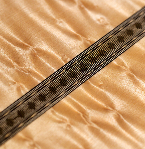 A close-up of the back of a 2021 Gabriele Lodi "Torres" classical guitar made of spruce and maple.