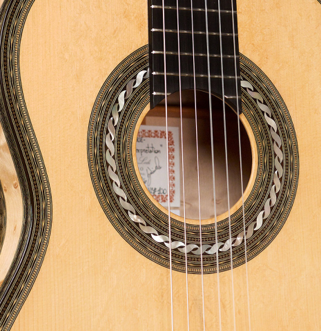 The soundboard and rosette of a 2021 Gabriele Lodi "Torres" classical guitar made of spruce and maple.