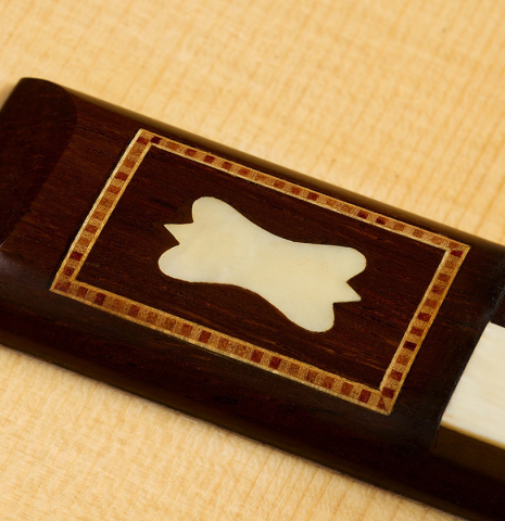 The bridge, tie-block and saddle of a 2020 Gabriele Lodi "Torres" classical guitar made of spruce and CSA rosewood