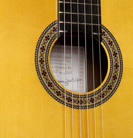 The soundboard and rosette of a 2021 Hermanos Sanchis Lopez &quot;Antonio Rey&quot; flamenco guitar made of spruce and Indian rosewood
