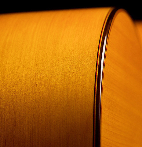 The side and binding of a 2022 Hermanos Sanchis Lopez &quot;Antonio Rey&quot; flamenco guitar made with spruce and cypress
