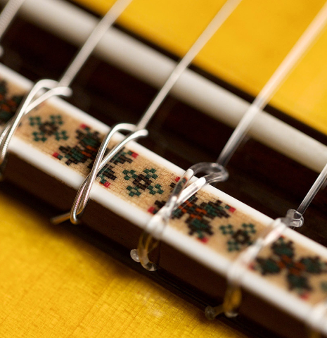 The bridge and saddle of a 2022 Hermanos Sanchis Lopez "Antonio Rey" flamenco guitar made with spruce and cypress
