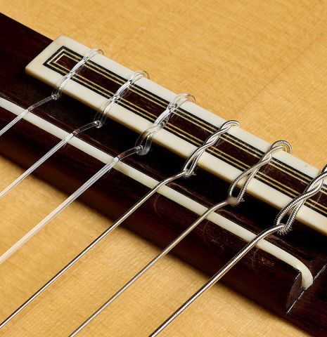 The bridge, tie-block and saddle of a 2009 Casimiro Lozano classical guitar made of spruce and African rosewood