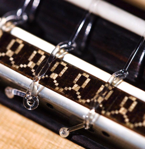 The bridge, tie-block and saddle of a 2020 Daniele Marrabello "A Nina" classical guitar made of spruce and Indian rosewood
