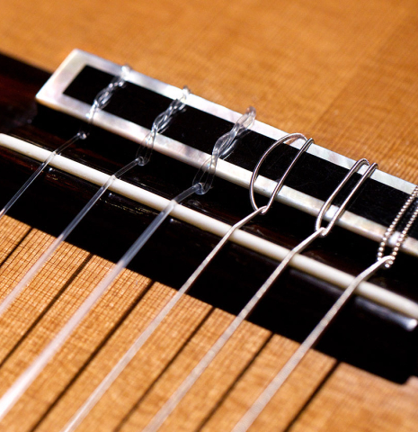 The bridge, tie-block and saddle of a 1994 Paco Santiago Marin classical guitar made of cedar and Indian rosewood