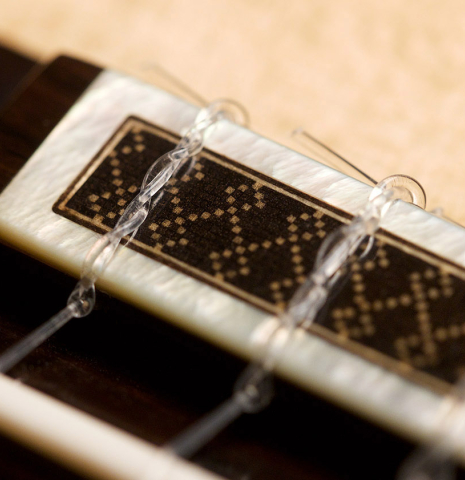 The bridge, tie-block and saddle of a 2021 Antonio Marin Montero classical guitar made of spruce and Indian rosewood
