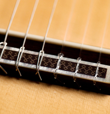 The bridge, tie-block and saddle of a 2005 Antonio Marin Montero classical guitar made of spruce and CSA rosewood