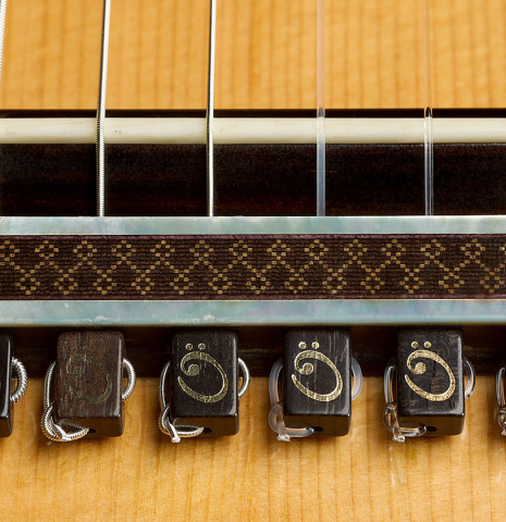 The bridge, tie-block and saddle of a 2004 Antonio Marin Montero classical guitar made of spruce and CSA rosewood