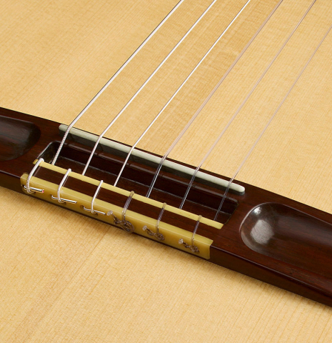 The bridge, tie-block and saddle of a 2006 Simon Marty (ex Scott Tennant) classical guitar made of spruce and cocobolo