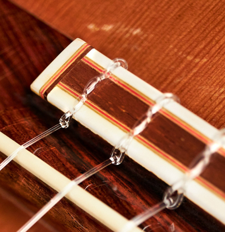 The bridge and saddle of a 1978 Robert Mattingly classical guitar made of cedar and CSA rosewood