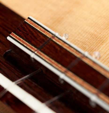 The tie block of a 2021 Claudio Meneghelli  "Hommage to Jose Romanillos" classical guitar made with spruce and Indian rosewood