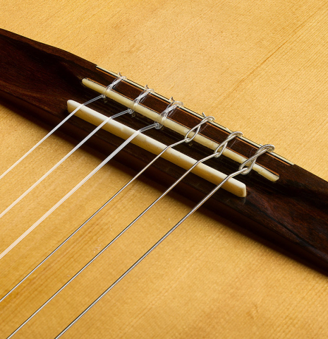 The bridge, tie-block and saddle of a 2002 Matthew Morello classical guitar made of spruce and ziricote