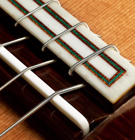 The bridge, tie-block and saddle of a 2017 Fernando Moreno classical guitar made of cedar and Indian rosewood
