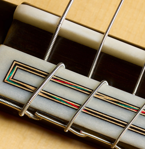 The bridge, tie-block and saddle of a 2026 Fernando Moreno classical guitar made of spruce and African rosewood