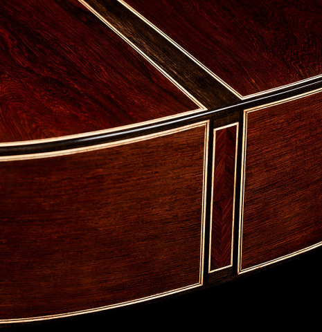 The back and sides at the foot of a 2025 Oscar Munoz classical guitar made of cedar and African rosewood