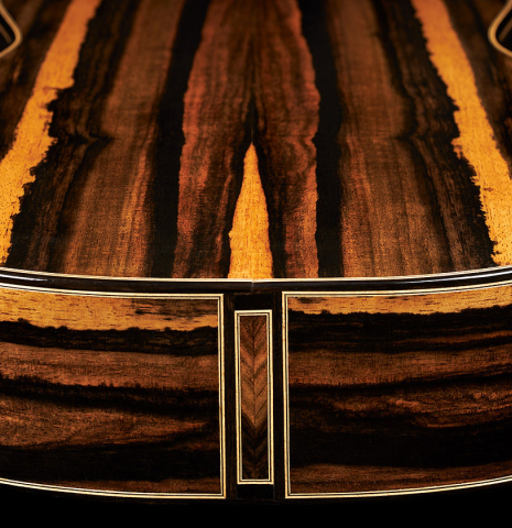 The back and sides at the foot of a 2024 Oscar Munoz classical guitar made of spruce and Makassar ebony