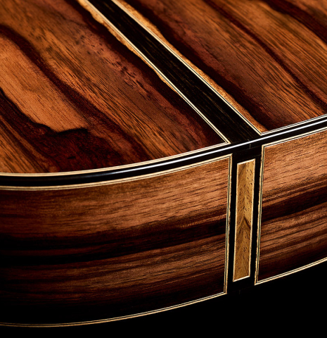 The back and sides at the foot of a 2026 Oscar Munoz classical guitar made of spruce and Makassar ebony