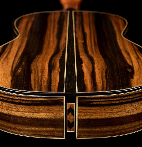 The back and sides at the foot of a 2026 Oscar Munoz classical guitar made of cedar and Makassar ebony