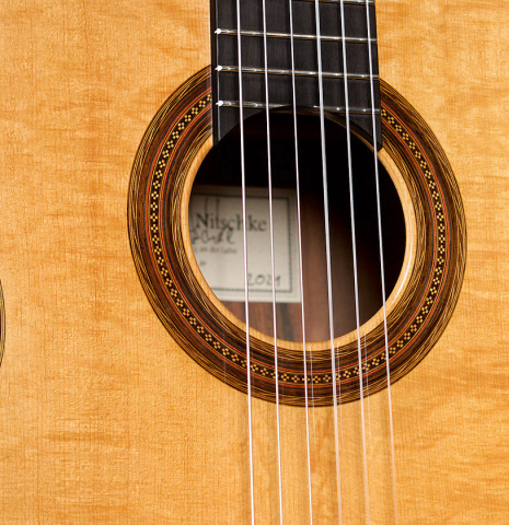 The bearclaw spruce top and rosette of a 2021 Stefan Nitschke "Hauser" classical guitar made with spruce and CSA rosewood