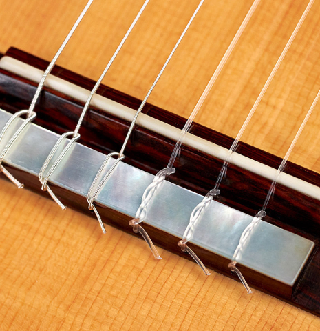 The bridge and saddle of a 2022 Stefan Nitschke "Hauser" classical guitar made with spruce and CSA rosewood