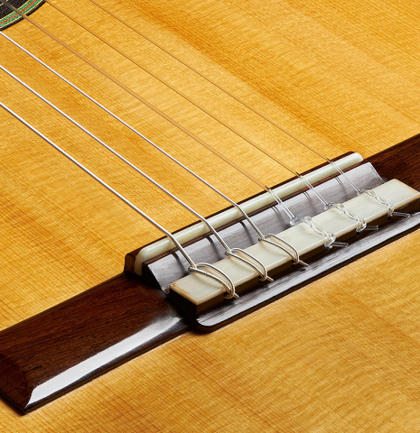 The bridge, tie-block and saddle of a 2023 Stefan Nitschke "Vicente Arias" classical guitar made of spruce and cypress