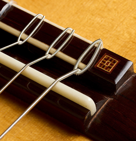 The bridge, tie-block and saddle of a 2019 Stefan Nitschke "Romanillos" classical guitar made of spruce and CSA rosewood