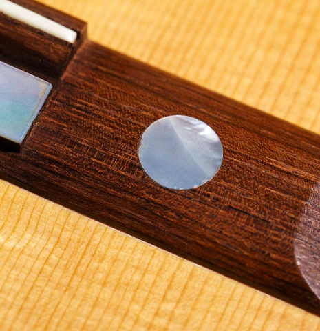 Closeup of Mother-of-pearl bridge inlay of a 1992 Ober/Blochinger classical guitar made of spruce and CSA rosewood