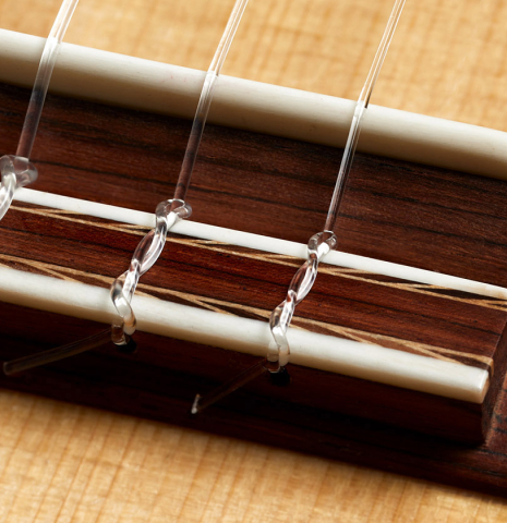 The bridge, tie-block and saddle of a 2000 Fritz Ober classical guitar made of spruce and maple
