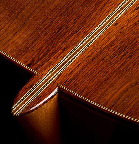 The heel, back binding and purfling of a 1997 Fritz Ober classical guitar made of spruce and CSA rosewood