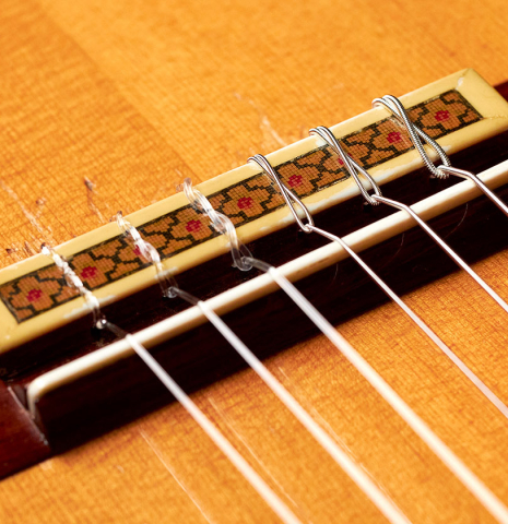 The bridge, tie-block, and saddle of a 1964 Jose Oribe classical guitar made of spruce and CSA rosewood
