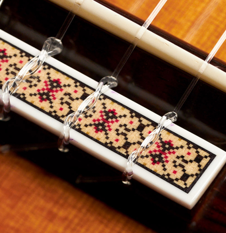 The bridge, tie-block and saddle of a 1980's Jose Oribe "Classic Professional A" classical guitar made of cedar and Indian rosewood