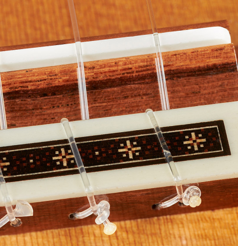 The bridge, tie-block and saddle of a 2023 Darragh O'Connell classical guitar made of cedar and Indian rosewood