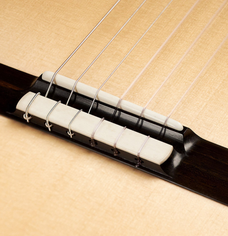 This is the bridge, tie-block and saddle of a 2023 Alexis Parducci classical guitar made with spruce and African rosewood.
