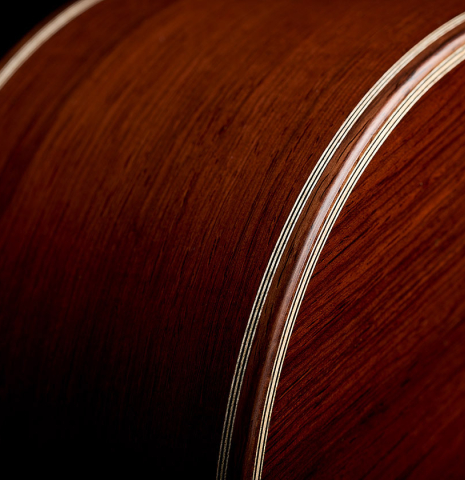 The back and side bindings of a 2026 Alexis Parducci classical guitar made of spruce and African rosewood