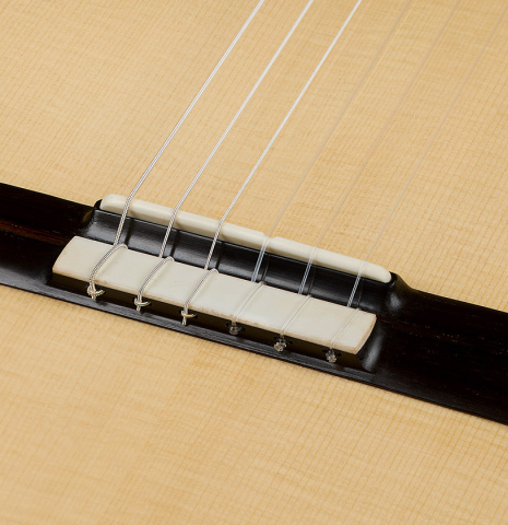 The bridge, tie-block and saddle of a 2026 Alexis Parducci classical guitar made of spruce and African rosewood