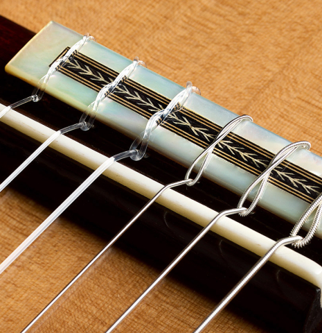 The bridge, tie-block and saddle of a 2026 Teodoro Perez "Especial - Bois de Rose" classical guitar made of cedar and African rosewood