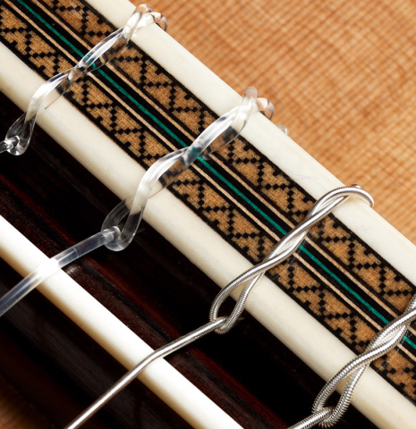 The bridge, tie-block and saddle of a 2024 Teodoro Perez "Maestro" classical guitar made of cedar and African rosewood