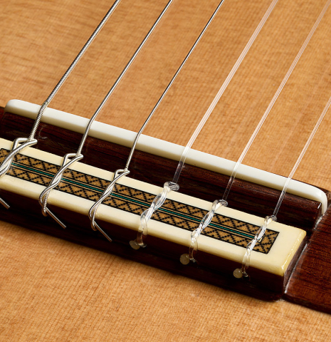 The bridge, tie-block and saddle of a 2025 Teodoro Perez "Maestro" classical guitar made of cedar and African rosewood