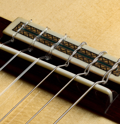 The bridge, tie-block and saddle of a 2025 Teodoro Perez "Maestro" classical guitar made of spruce and African rosewood