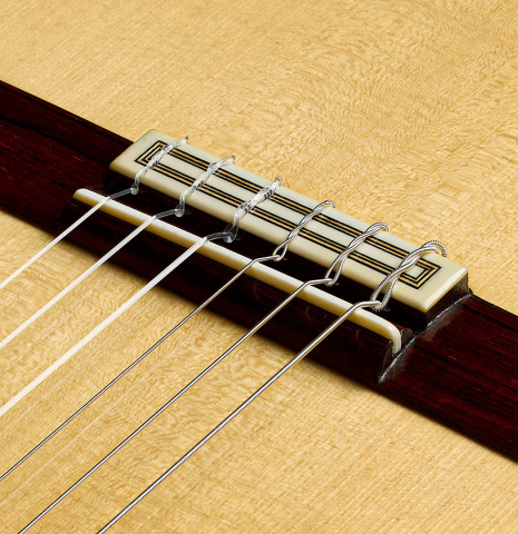 The bridge, tie-block and saddle of a 2025 Teodoro Perez "Concierto" classical guitar made of spruce and African rosewood