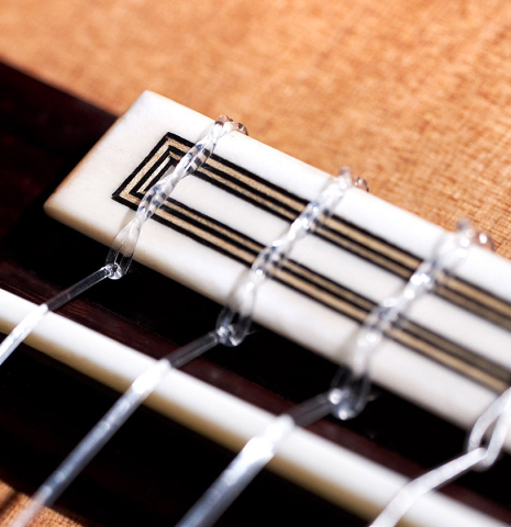 The bridge and tie block of a 2023 Teodoro Perez "Concierto" classical guitar made of cedar and Indian rosewood.