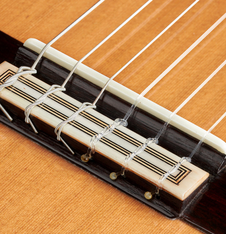 The bridge, tie block and saddle of a 2024 Teodoro Perez "Concierto" classical guitar made of cedar and Indian rosewood.