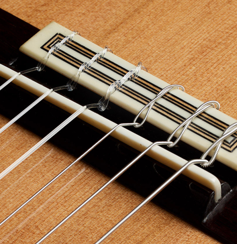 The bridge, tie-block and saddle of a 2025 Teodoro Perez "Concierto" classical guitar made of cedar and Indian rosewood.