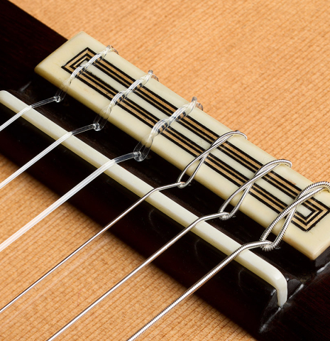 The bridge, tie-block and saddle of a 2026 Teodoro Perez "Concierto" classical guitar made of cedar and Indian rosewood