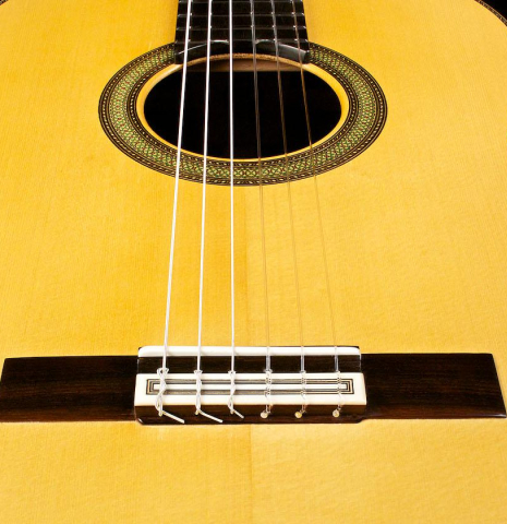 The bridge, tie-block and saddle of a 2015 Teodoro Perez "Concierto" classical guitar made of spruce and Indian rosewood