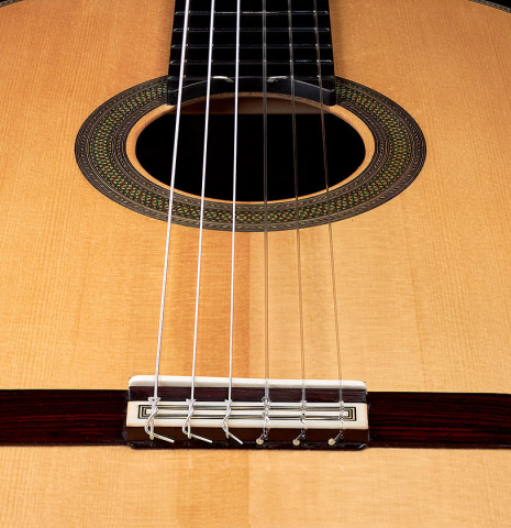The bridge and saddle of a 2022 Teodoro Perez &quot;Concierto&quot; classical guitar made with spruce and Indian rosewood