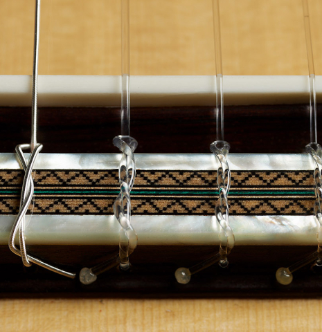 The bridge, tie-block and saddle of a 2025 Teodoro Perez "Especial" classical guitar made of spruce and African rosewood.