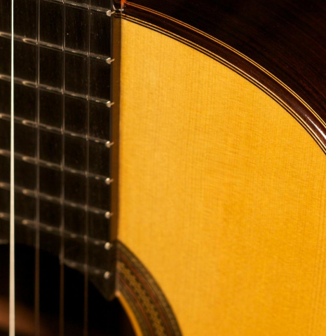 The upper bout of the top and fingerboard of a 2013 Teodoro Perez "Madrid" classical guitar made of spruce and Indian rosewood