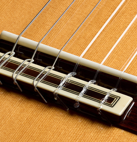 The bridge, tie-block and saddle of a 2025 Teodoro Perez "Madrid" classical guitar made of cedar and Indian rosewood