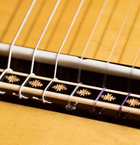 The diamond ornaments on the bridge of a 2020 Erez Perelman classical guitar made of spruce and cypress